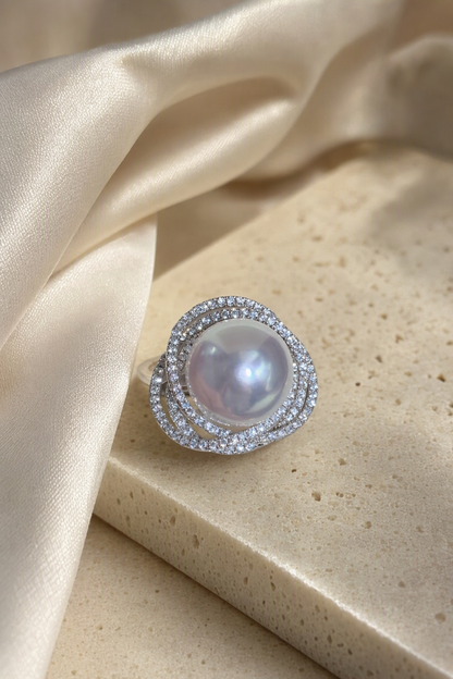 11–12mm White South Sea Pearl Double Halo Sterling Silver Ring in a still-life ivory silk luxury environment