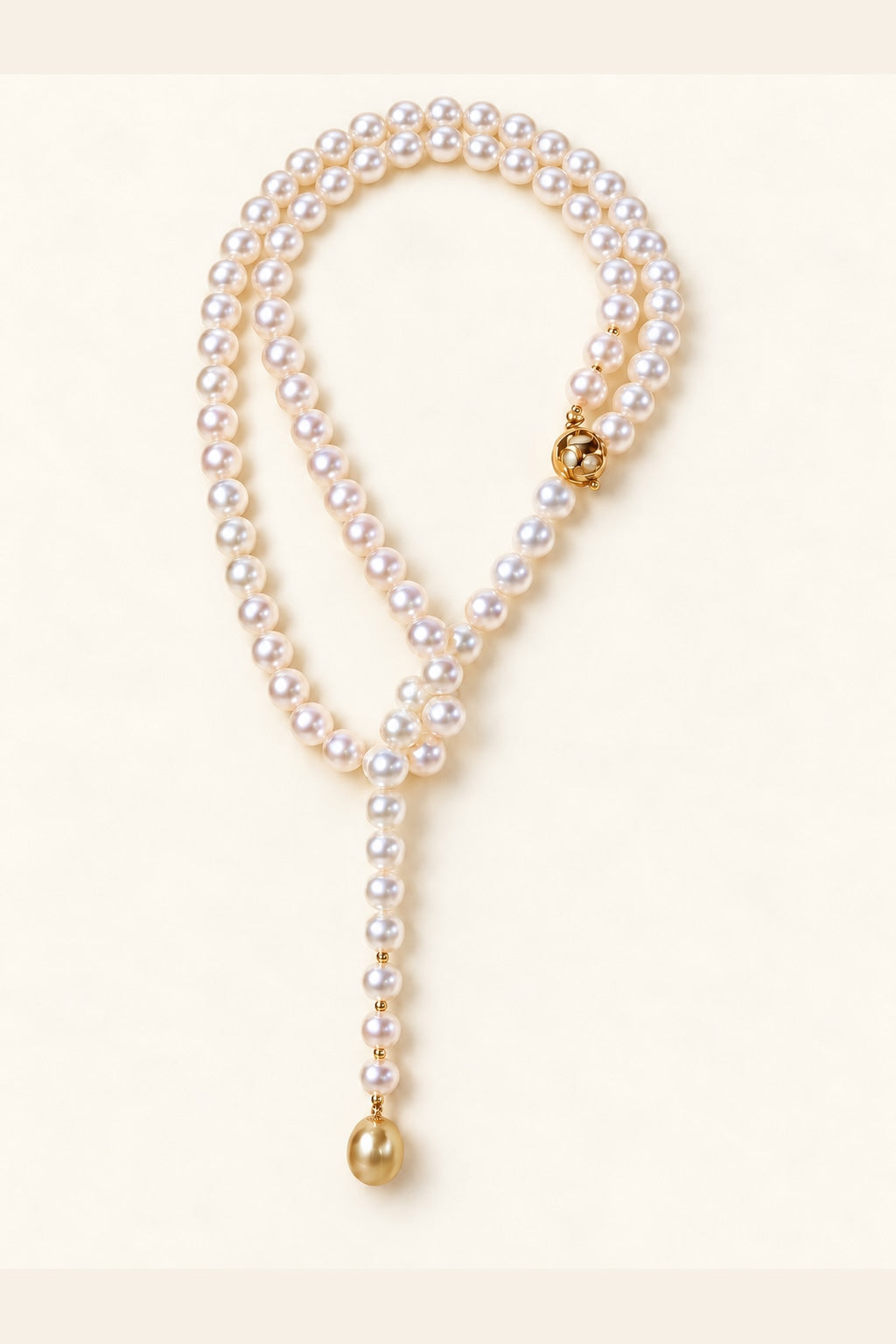 High Luster White pearls 8–9 mm; Golden South Sea terminal pearl 11–12 mm Cultured Freshwater Pearl with Golden South Sea Pearl terminal necklace on a cream white background