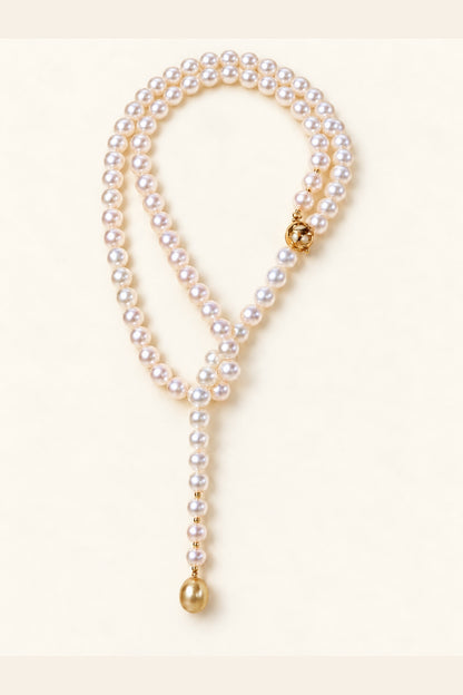 High Luster White pearls 8–9 mm; Golden South Sea terminal pearl 11–12 mm Cultured Freshwater Pearl with Golden South Sea Pearl terminal necklace on a cream white background