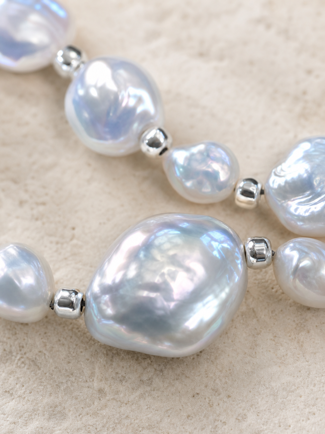 Close-up of silver-blue freshwater pearl bracelet showing baroque texture and mirror luster