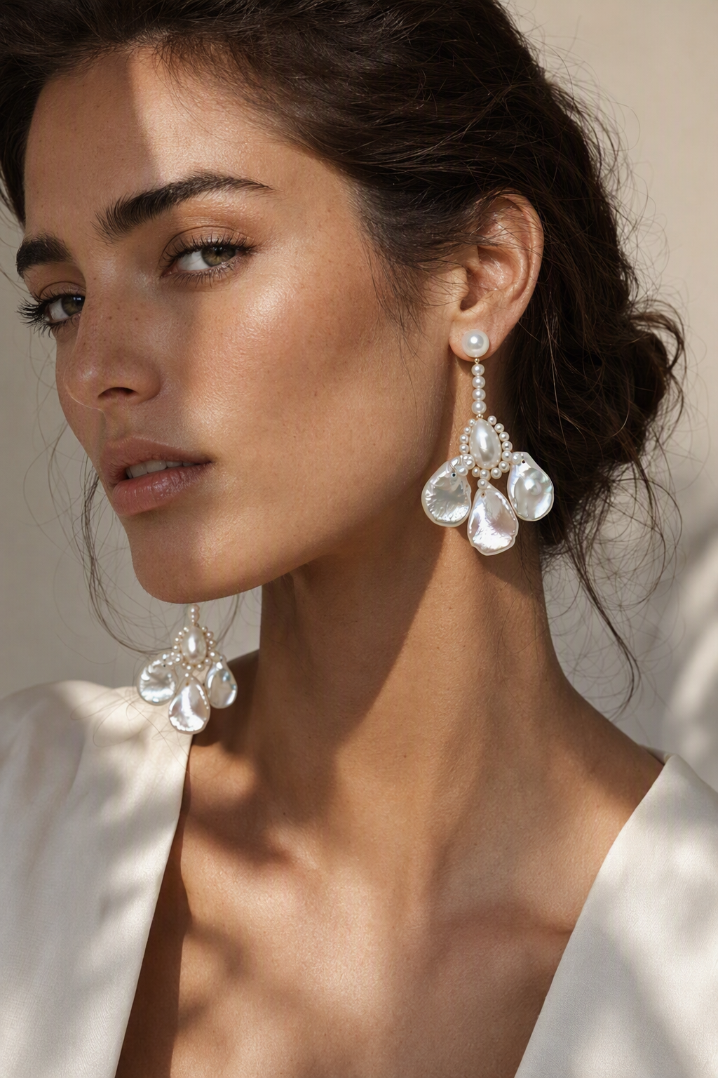 Model wearing Aurora Luster Custom Freshwater Pearl dangle earrings naturally on the earlobe