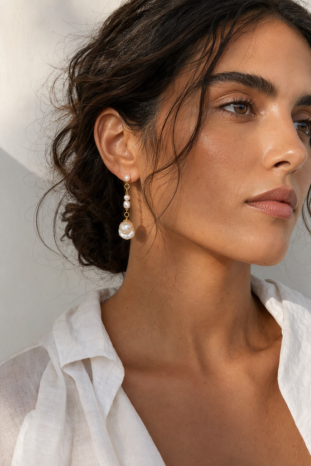 Model wearing High Luster Freshwater Pearl dangle earrings naturally on the earlobe