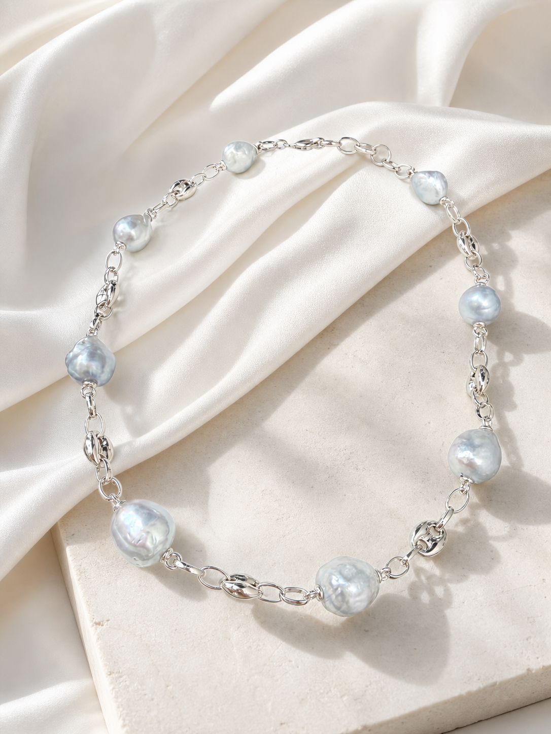 Freshwater baroque pearl necklace in blue-gray color featuring mirror-like luster and silver chain links