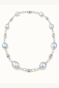 Blue freshwater pearl necklace with mirror-like luster and large baroque pearls on cream white background