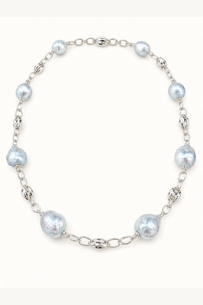 Blue freshwater pearl necklace with mirror-like luster and large baroque pearls on cream white background