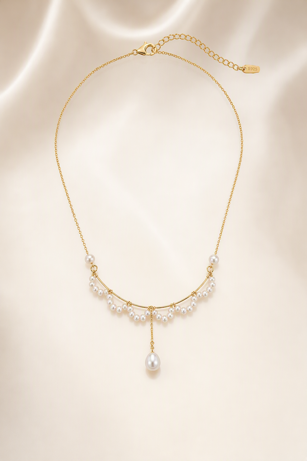 Mirror Luster 2–3 mm fringe pearls; 4–5 mm side pearls; 6–9 mm teardrop focal pearl Freshwater Pearl necklace on a cream white background