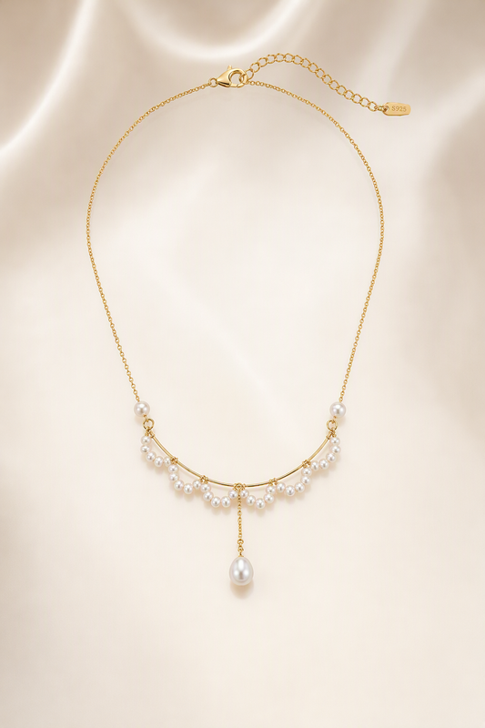 Mirror Luster 2–3 mm fringe pearls; 4–5 mm side pearls; 6–9 mm teardrop focal pearl Freshwater Pearl necklace on a cream white background