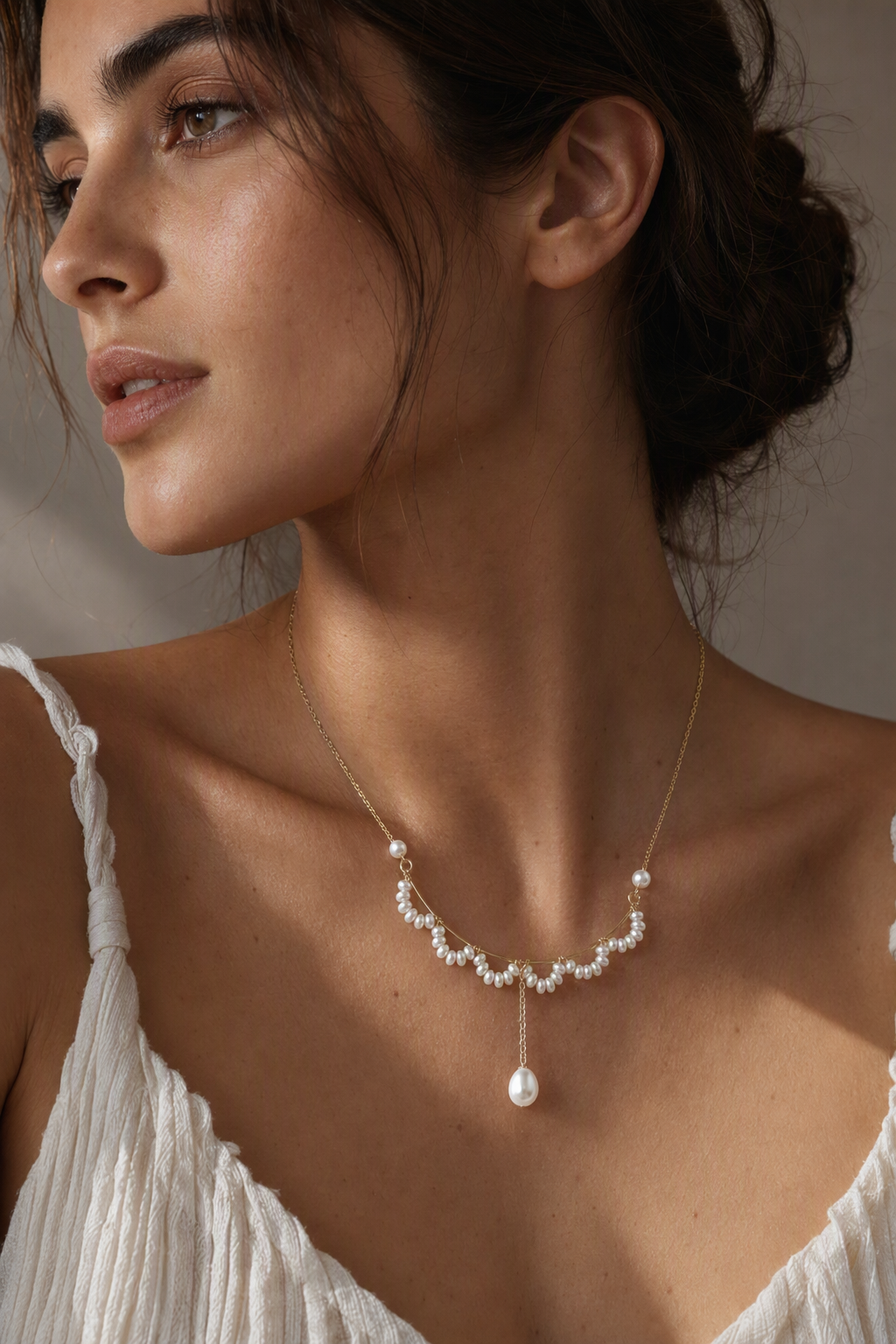 Model wearing Mirror Luster 2–3 mm fringe pearls; 4–5 mm side pearls; 6–9 mm teardrop focal pearl Freshwater Pearl necklace naturally at the neckline
