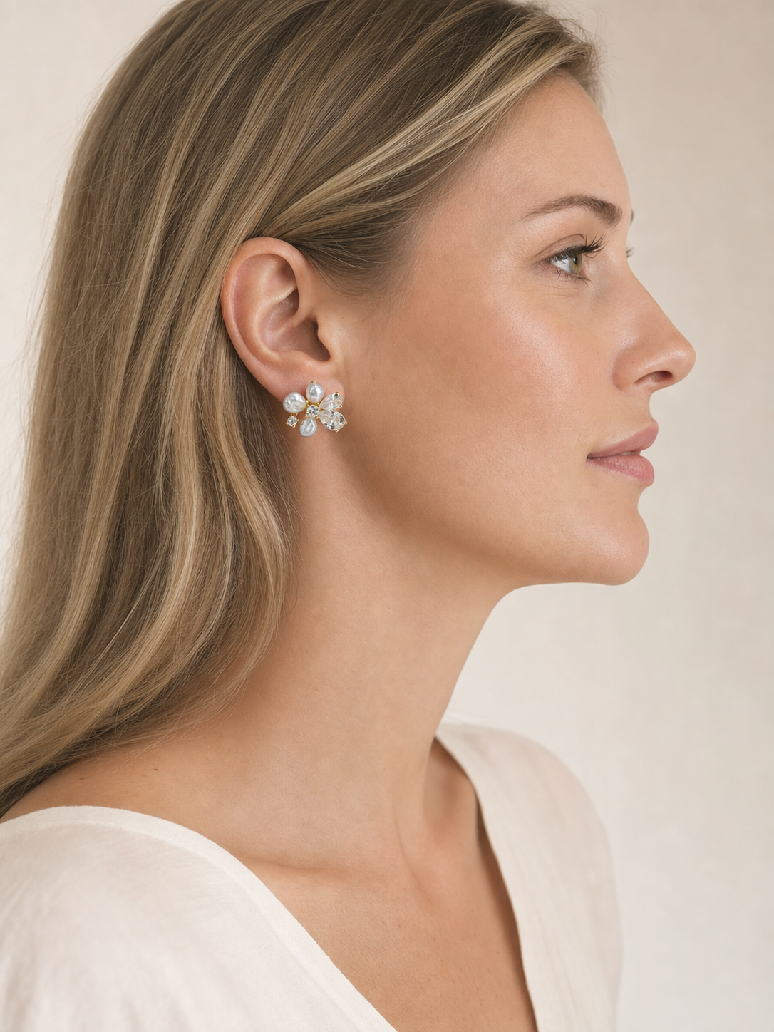 Western model wearing freshwater keshi pearl flower stud earrings in side profile