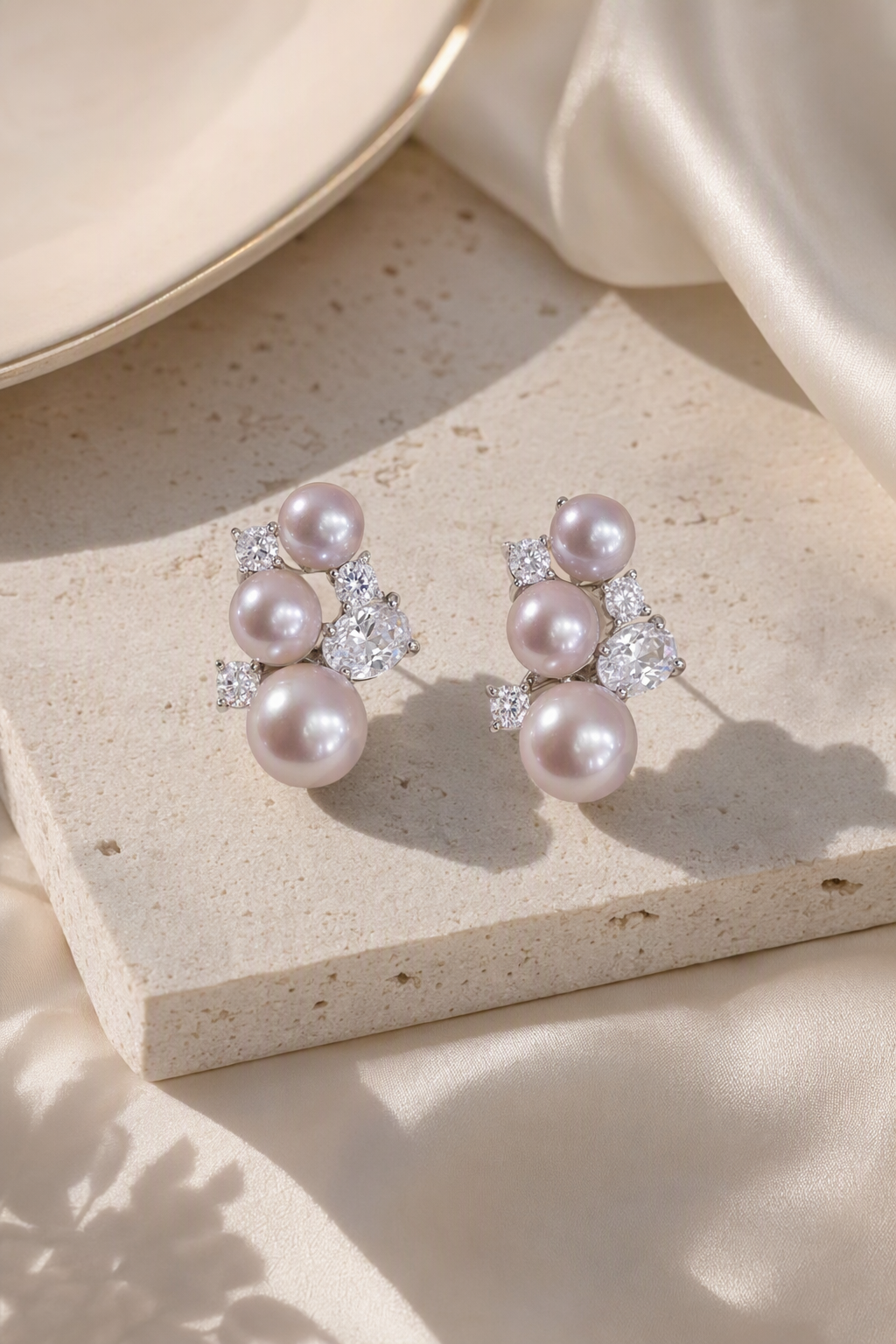 Mirror Luster 4–10 mm Graduated Freshwater Pearl stud earrings in an elegant still-life luxury setting