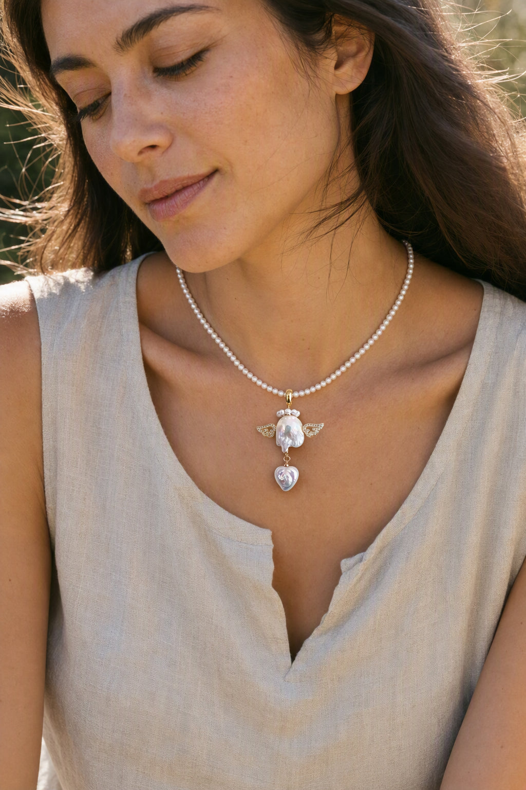 Model wearing the Winged Angel Heart Drop baroque pearl pendant necklace by Pearlivo