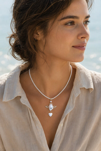 Model wearing the Crystal Wing Heart Drop baroque pearl pendant necklace by Pearlivo