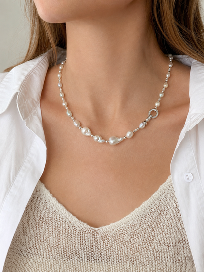 White freshwater pearl necklace with silver clasp detail and mirror-like luster on model