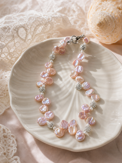 Pink purple freshwater pearl necklace styled on cream background with mirror luster pearls