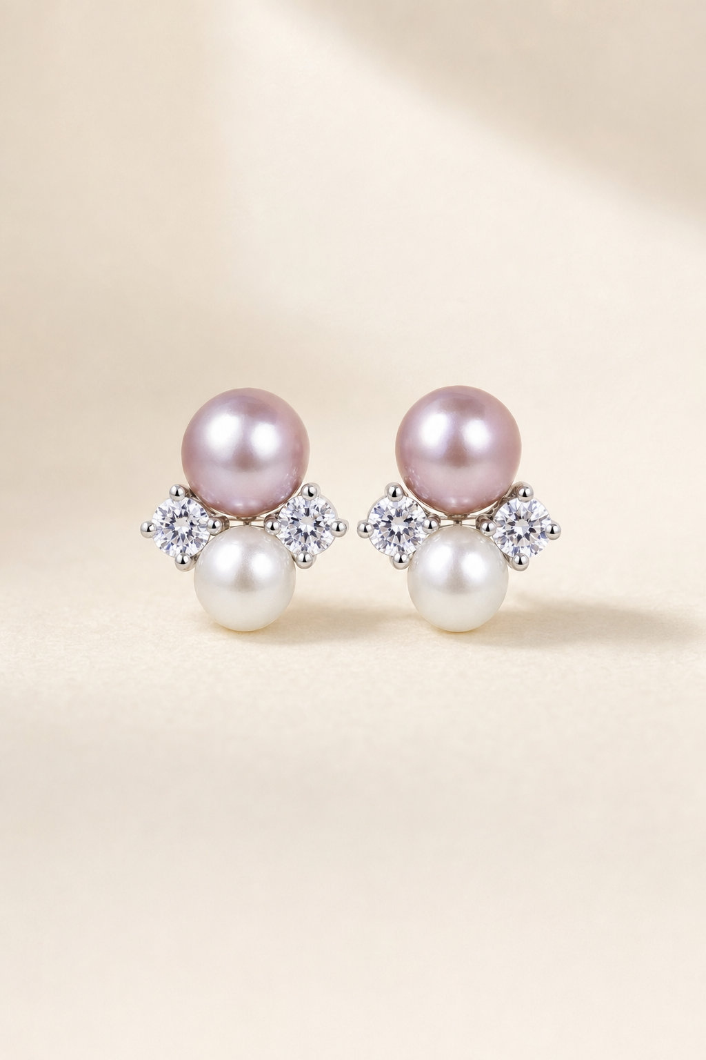 Mirror Luster 9–10 mm purple pearl with 6–7 mm white pearl Freshwater Pearl stud earrings on a cream white background