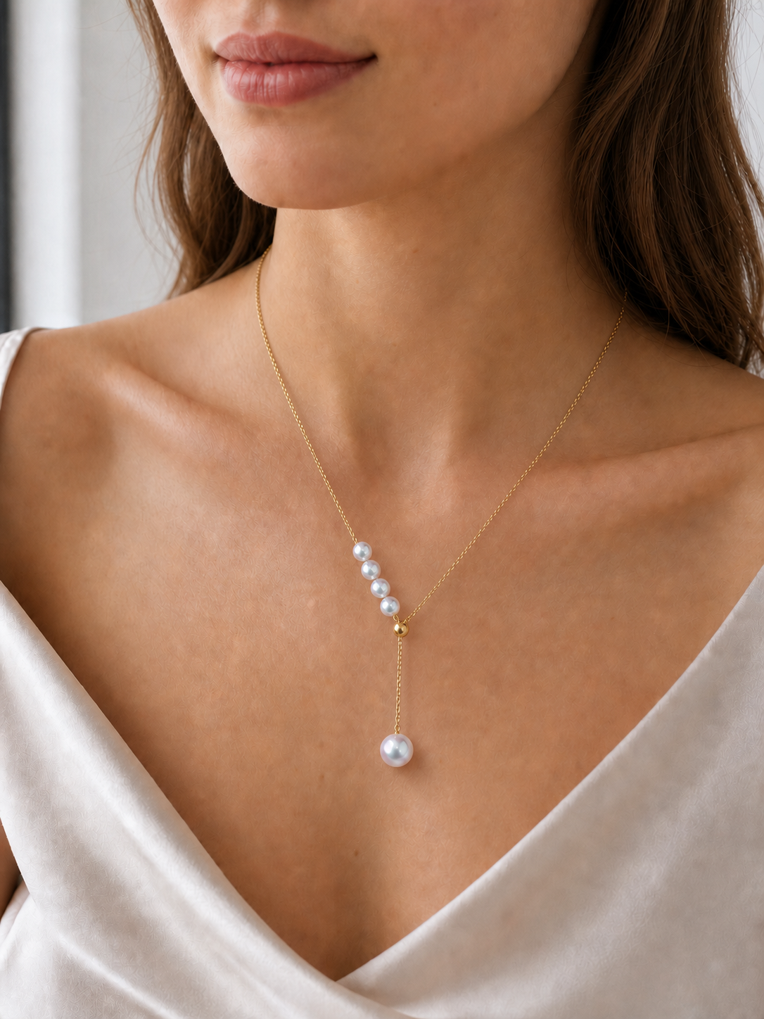 Akoya pearl necklace on model showing white mirror-luster pearls and delicate gold chain
