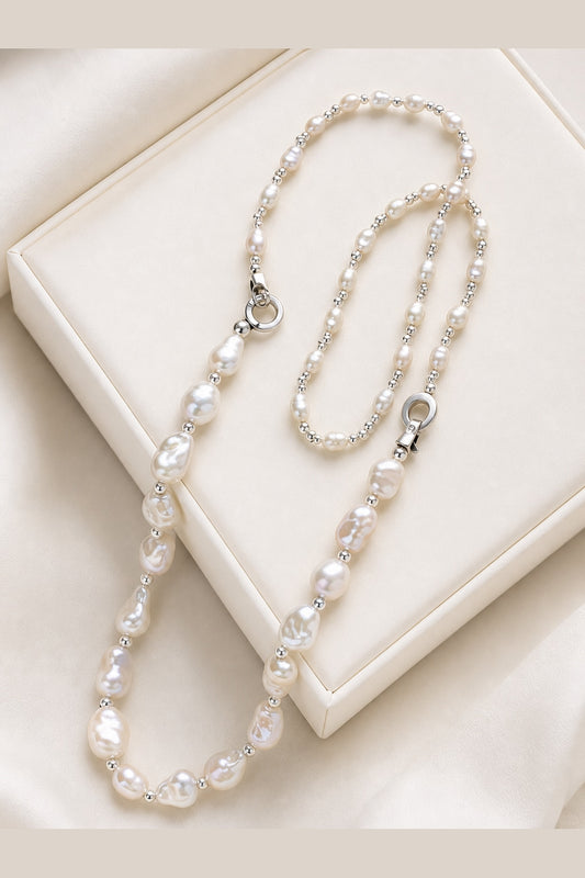 White freshwater baroque pearl necklace with mirror-like luster on a luxury display surface