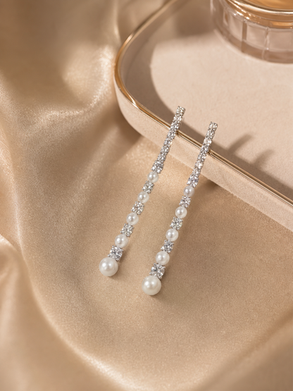 White freshwater pearl meteor earrings styled on satin with mirror-like luster and crystal sparkle