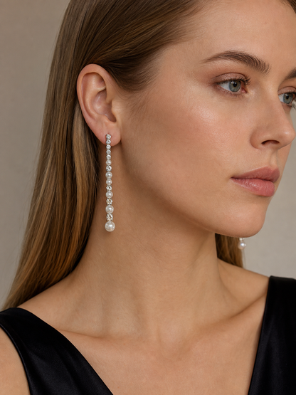 Model wearing white freshwater pearl meteor earrings with mirror-like luster and silver sparkle